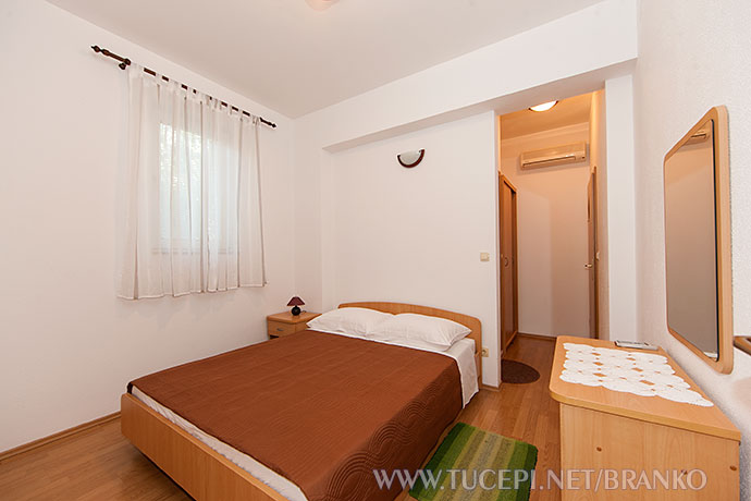 bedroom with dressing mirror, window, air-conditioned